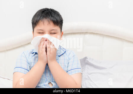 Obèses asiatique fat boy blowing le nez par les tissus, les soins de santé et des malades concept Banque D'Images