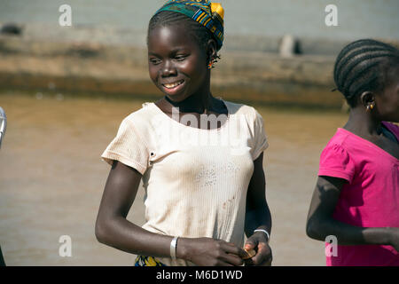 Une jeune adolescente autochtones, ethniques, tribales, fille Bozo souriant, portant un t-shirt. Le Mali, Afrique de l'Ouest. Banque D'Images