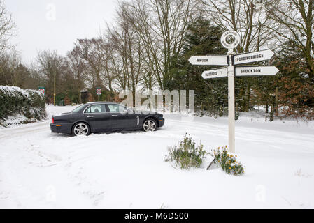 Jaguar voiture garée près d'un panneau 4 contacts en haut d'une colline dans la neige suite orage Emma, Godshill, New Forest, Hampshire, England, UK Banque D'Images