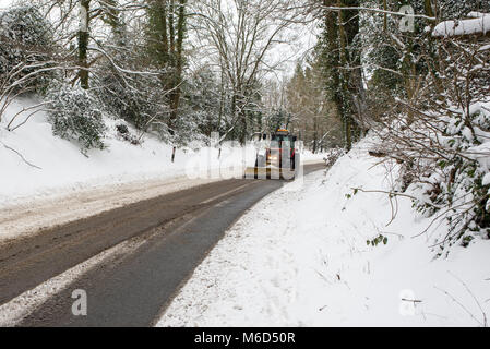 Fordingbridge, New Forest, Hampshire, Angleterre, Royaume-Uni, mars 2018, Météo : tracteur avec un chasse-neige pièce jointe sur une route de campagne pendant une tempête Emma. Banque D'Images