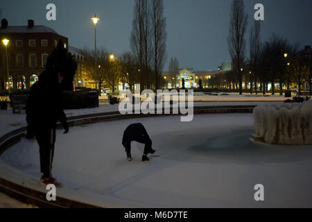 Welwyn Garden City, Royaume-Uni. 2e Mar, 2018. Beaucoup de neige est tombée toute la journée à Welwyn Garden City. Enfants jouant sur le dessus de la fontaine gelée. Crédit : Andrew Steven Graham/Alamy Vivre Newsz Banque D'Images