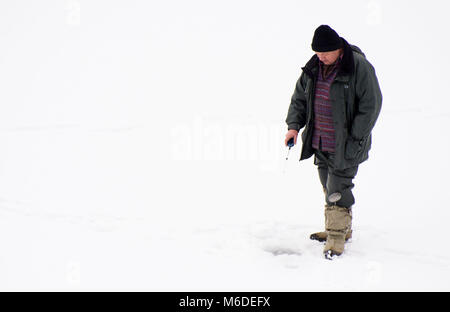 03 mars 2018, l'Allemagne, Schluchsee : une glace fisher espère une grosse prise sur le lac de schluch congelé 'Schluchsee' dans le sud de la Forêt-Noire. Le Schluchsee est le plus grand lac dans la Forêt Noire. Photo : Steffen Schmidt/dpa Banque D'Images