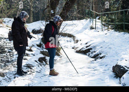 Oker, Allemagne. Le 3 mars 2018. Deux trekkeurs attentivement un ruisseau gelé dans le Harz. Basse-saxe connaît actuellement des températures froides Photo : Swen Pförtner/dpa dpa : Crédit photo alliance/Alamy Live News Banque D'Images