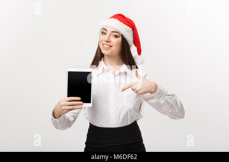 Concept d'affaires - young caucasian business woman en thème de Noël montrant et en pointant sur tablette numérique. Banque D'Images