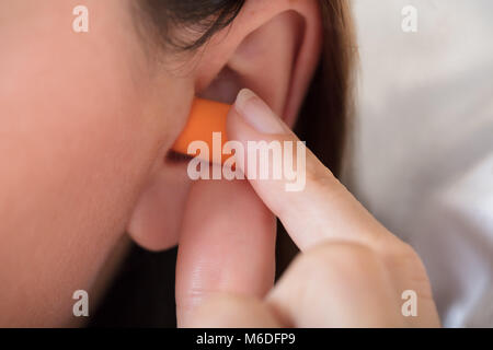 Close-up of a Woman Putting écouteur dans son oreille Banque D'Images