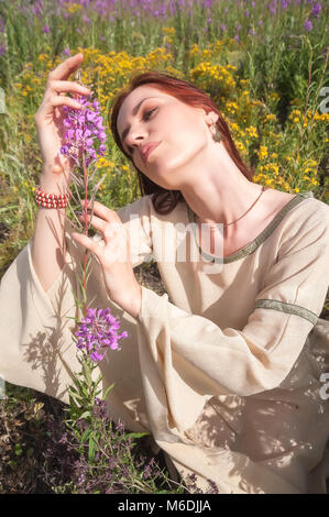 Belle-fille cheveux rouge on meadow Banque D'Images