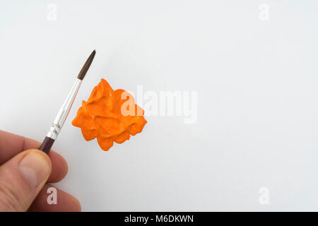 Une goutte de peinture acrylique couleur orange sur une surface blanche Banque D'Images