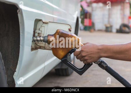 Le pistolet à main ajouter du carburant dans la voiture à la station de charge Banque D'Images