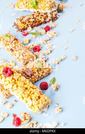 Petit-déjeuner sain et snack-concept, avec granola maison de framboises fraîches et les écrous et les barres granola, sur fond bleu lumineux copy space Banque D'Images