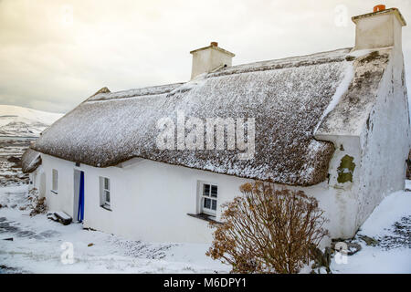 Irish cottage de chaume couvert de neige en pays lane le Valentia Island, comté de Kerry, Irlande Banque D'Images