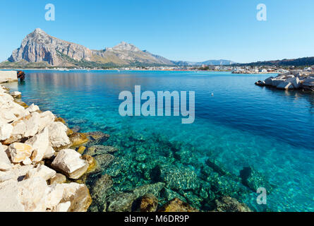 La plage de San Vito lo Capo avec de l'eau claire d'azur et Monaco, loin dans le nord-ouest de la Sicile, en Italie. Banque D'Images