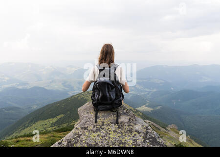 Randonneur fille siège au rock en zone de montagne magnifique et ressemble à distance sans fin Banque D'Images
