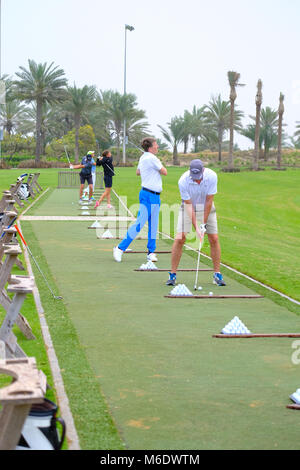 Groupe de joueurs de golf train / pratiquant à Saadiyat Beach Golf Course, Abu Dhabi ÉMIRATS ARABES UNIS. Banque D'Images