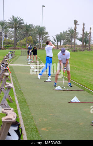 Groupe de joueurs de golf train / pratiquant à Saadiyat Beach Golf Course, Abu Dhabi ÉMIRATS ARABES UNIS. Banque D'Images