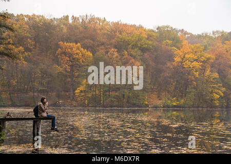 Girl bénéficie d'reste et boit du café près du lac au parc de la nature de l'or moelleux jour d'automne Banque D'Images