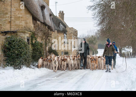 Les cotswolds du Nord chassent les fosses en passant devant des cottages à toit de chaume dans la neige d'hiver. Broadway, Cotswolds, Worcestershire, Angleterre Banque D'Images