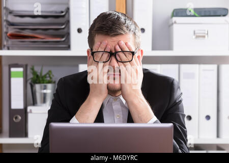 Close-up of a Young Businessman Sitting fatigué In Office Banque D'Images