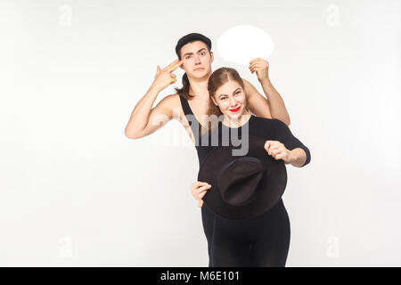 Règles de circulation. Couple au volant d'une voiture, l'homme canon montrant signe. Studio shot, isolé sur fond blanc Banque D'Images