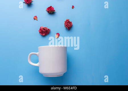 Mise à plat avec des fleurs tasse à café tasse au-dessus des fleurs. Banque D'Images