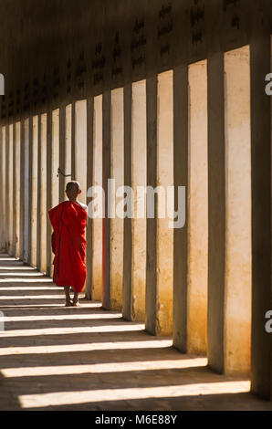 Moine Bouddhiste novice à marcher le long de l'escalier, la Pagode Shwezigon, Nyaung U Bagan, Myanmar (Birmanie), l'Asie en février - les colonnes et les ombres Banque D'Images