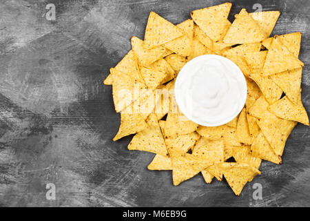 Sauce crémeuse au bol blanc et des nachos. Vue de dessus, copiez l'espace. Arrière-plan de l'alimentation Banque D'Images