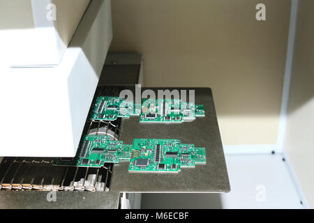 Automatisation de l'assemblage de la machine de carte de circuit imprimé dans l'usine pour la production de composants de l'ordinateur. Le processus de soudure du conseil. Banque D'Images