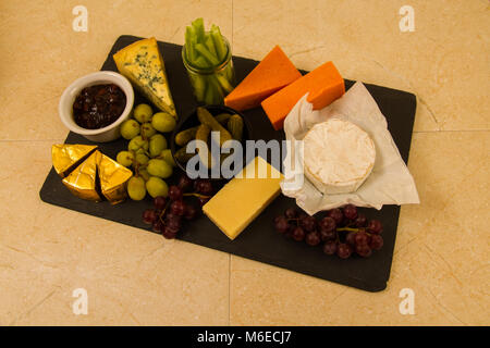 Plateau de fromages, de partage, de fromage, red leicester, stilton, cheddar, brie, camembert, raisins, cornichons au vinaigre, le céleri, le cornichon ou sla sur chutney Banque D'Images