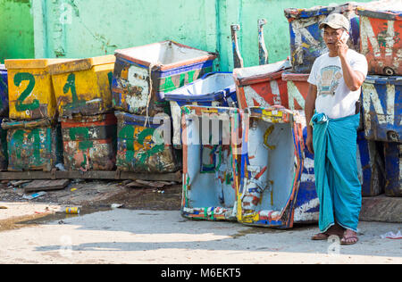 Man talking on mobile phone debout près de caisses vides à San Pya marché aux poissons, Yangon, Myanmar (Birmanie), l'Asie en février Banque D'Images