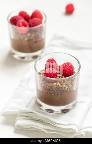 Dessert au chocolat dans les verres avec les framboises. Mousse au chocolat ou au lait en partie lunettes avec les baies fraîches, copiez l'espace. Banque D'Images