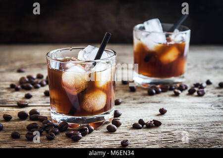 Black Russian Cocktail avec de la vodka et la liqueur de café. Des boissons Boozy Black Russian boisson avec les grains de café sur fond de bois avec spa de copie Banque D'Images