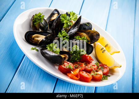 Moules cuites avec du citron et des tomates cerises Banque D'Images