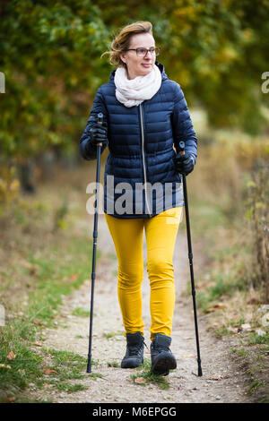 Marche nordique - moyen-âge woman working out in city park Banque D'Images