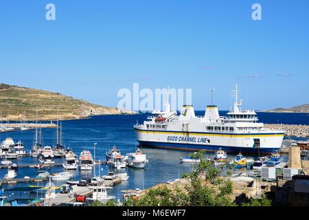 Les bateaux de pêche et yachts amarrés dans le port avec le Gozo ferry amarré dans le port à l'arrière, Mgarr, Gozo, Malte, l'Europe. Banque D'Images