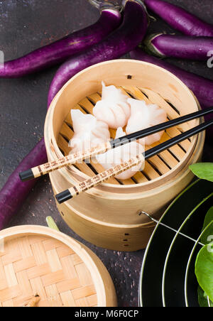 Dim sum boulettes en bateau à vapeur avec des légumes chinois sur fond vintage Banque D'Images