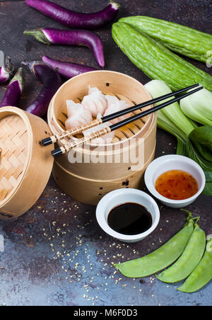 Dim sum boulettes en bateau à vapeur avec des légumes chinois sur fond vintage Banque D'Images