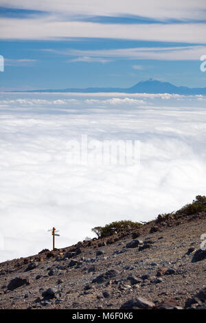 Vue depuis le Pico de la nieve en La Palma, Espagne à Tenerife comme flottant sur les nuages, un signe ainsi au premier plan. Banque D'Images