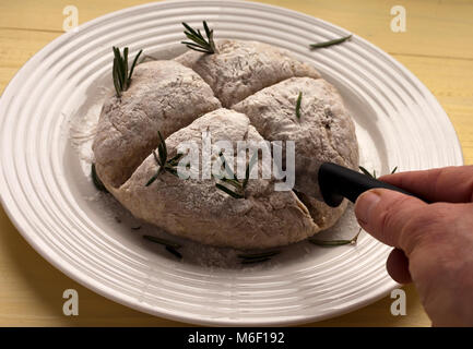 Quatre tranches Baker dans score des Irish Soda Bread pour St Patrick's Day. L'Encart d'herbes de romarin Banque D'Images