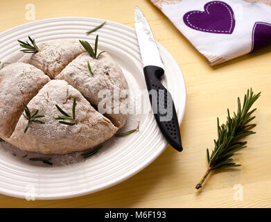 Quatre tranches Baker dans score des Irish Soda Bread pour St Patrick's Day. L'Encart d'herbes de romarin Banque D'Images