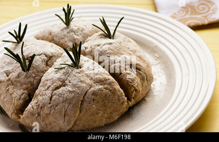 Quatre tranches Baker dans score des Irish Soda Bread pour St Patrick's Day. L'Encart d'herbes de romarin Banque D'Images