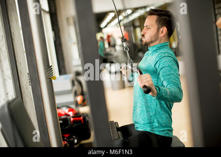 Bel homme faire excersise sur une machine lat in gym Banque D'Images