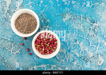 Assortiment d'herbes médicinales à sec les bourgeons roses et la lavande dans des bols. Banque D'Images