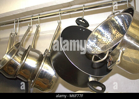 Les casseroles et poêles suspendu à un rail dans une cuisine domestique Banque D'Images