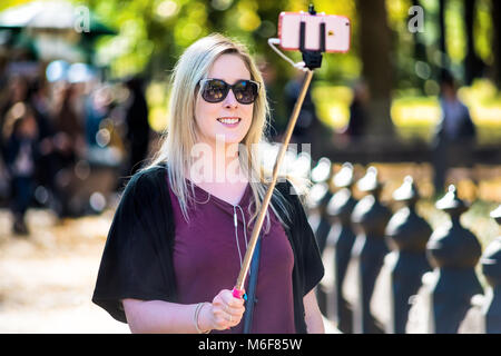 La ville de New York, USA - 28 octobre 2017 : Manhattan NYC Central Park avec un seul jeune heureux femme fille blonde millénaire selfies en photo avec Banque D'Images