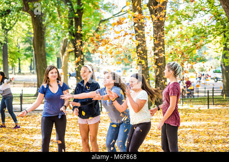 La ville de New York, USA - 28 octobre 2017 : Manhattan NYC Central Park avec des arbres, les jeunes adolescentes amis groupe de jeter les feuilles en l'air en automne Banque D'Images