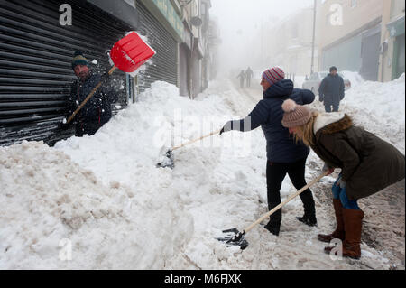 Brynmawr, Blaenau Gwent, dans le sud du Pays de Galles, Royaume-Uni. 3 mars, 2018. Les propriétaires de boutiques déneiger le magasin fronts. Plusieurs voitures sont encore couvert de neige. Après les deux derniers jours battues par la tempête Emma, la neige continue de tomber et c'est très brumeux, mais les vents ont diminué considérablement en Brynmawr, Blaenau Gwent, Galles du Sud, dans le sud du Pays de Galles au Royaume-Uni. (La plus haute ville du Pays de Galles.) © Graham M. Lawrence/Alamy Vivre Newswoman, Banque D'Images