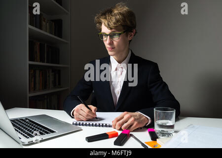 Déterminé et confiant young businessman travaille tard heures au bureau le projet afin de satisfaire les délais. Banque D'Images