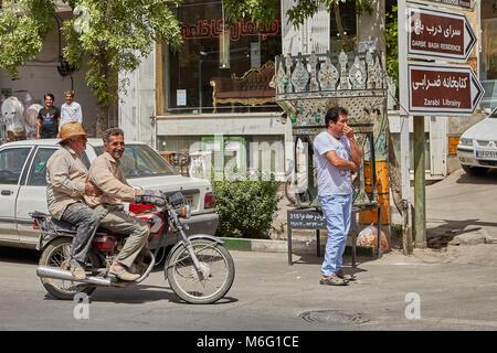 Kashan, Iran - avril 27, 2017 : l'homme est à cheval une moto avec passager sur une rue animée. Banque D'Images