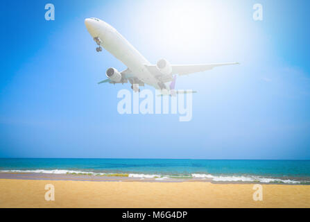 Plane flying sur ciel bleu avec fond de nuage sur plage et mer tropicale. Banque D'Images