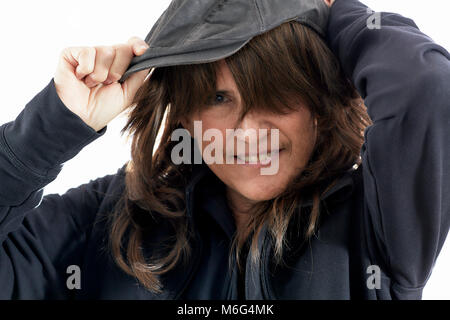 Belle femme d'âge moyen avec brown dégradées smiling tout en mettant sur un cap conduite isolated on white Banque D'Images