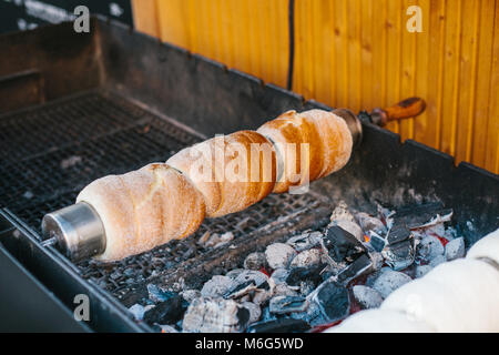 Gâterie sucrée traditionnelle tchèque Trdelnik . Pour se préparer à une brochettes en bois sur des charbons ardents. Un plat populaire parmi les touristes. Banque D'Images